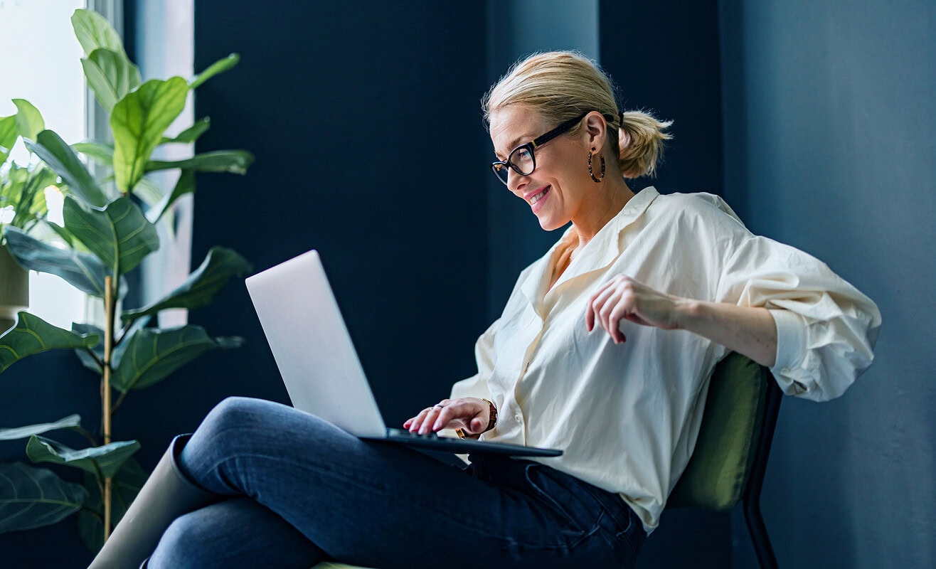 Frau arbeitet mobil am Laptop – regional verfügbare Glasfaserangebote für Unternehmen und Selbstständige von AVACOMM