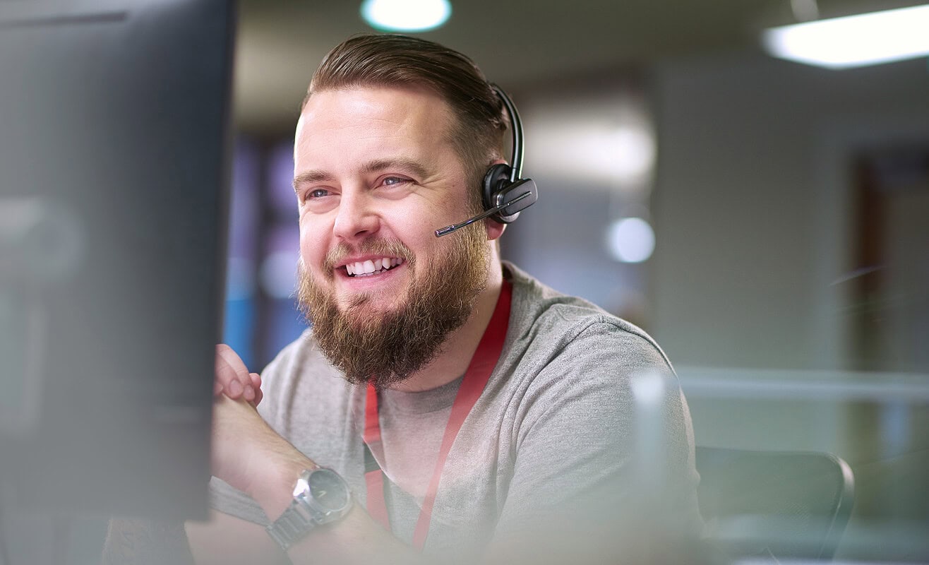 Mitarbeiter im Kundenservice mit Headset – persönlicher Support rund um Glasfaserlösungen bei AVACOMM