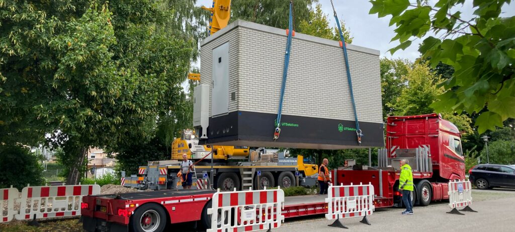 PoP-Aufstellung im Achental in Übersee, 10. September 2025. Der Point of Presence wird mit einem roten Kran zentimetergenau zauf den Bestimmungsort abgeladen.