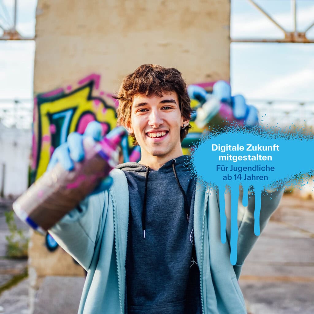 Jugendlicher Graffiti künstler hält lächelnd zwei Spraydosen Richtung Kamera